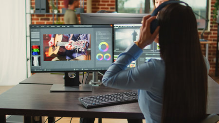 Female cinematographer editing video montage in post production studio office, improving footage quality on creative software. Artist designer working on movie or film, filmmaking industry.の写真素材