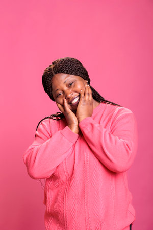 African american woman posing with overjoyed happy facial expressions on camera, feeling relaxed and...