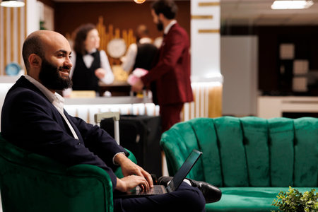 Businessman waiting in reception lobby, wearing elegant suit and preparing to check in. Worker travelling on business trip to attend executive board meeting at international headquarters.の写真素材