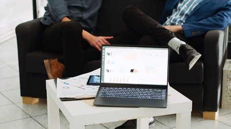 Online agency analytics on laptop in coworking space, running program with sales statistics for unicorn business development. Successful investment plan with marketing data on device.の写真素材