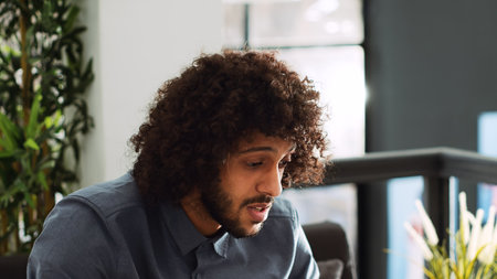 Businessman connects on online videocall in coworking space to explain research development to manager, telework conference. Professional developer using data analytics at meeting.の写真素材