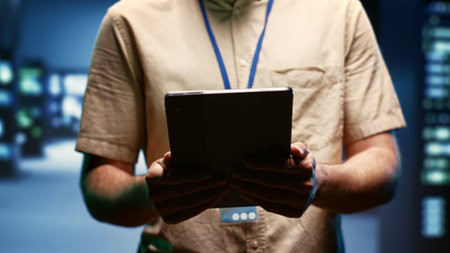 Programmer doing annual auditing, extending high tech facility hardware life span and avoiding downtime. Developer checking supercomputer infrastructure for power fluctuations, close upの素材