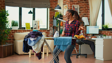 Young girlfriend enjoying doing ironing work at home, having fun listening to music and ironing...