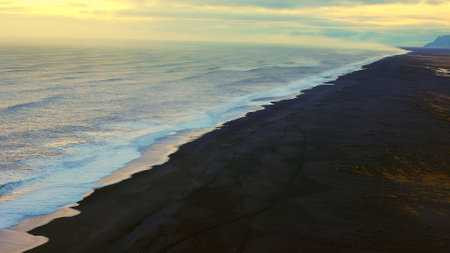 Nordic coastline with black sand beach and beautiful landscape panoramic view, ocean waves. Icelandic scenery with spectacular beach with stones and tides, arctic paradise. Handheld shot.の写真素材