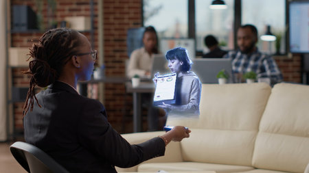 BIPOC employee in augmented reality teleconference meeting in high tech office talking with...