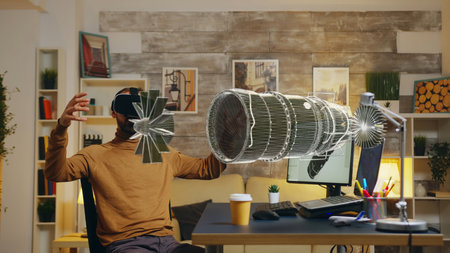 Freelancer with virtual reality goggles developing industrial turbine on manufacturing 3D rendering computer software, visualizing final result using holographic augmented reality technologyの写真素材
