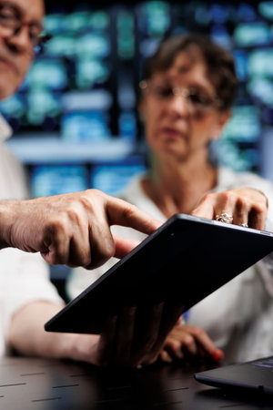 Elderly engineers working to maintain uptime in high tech data center. Experienced technicians...