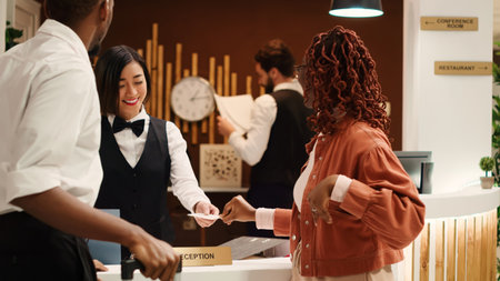 Tourists finishing vacation trip, handing out room card key to cheerful friendly receptionists...
