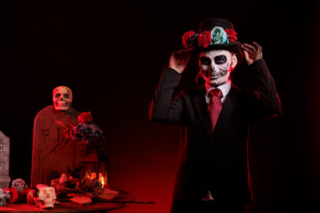 Beautiful model in costume with skull make up celebrating traditional mexican holiday with goddess of death costume. La cavalera catrina culture celebration with body art over black background.の写真素材