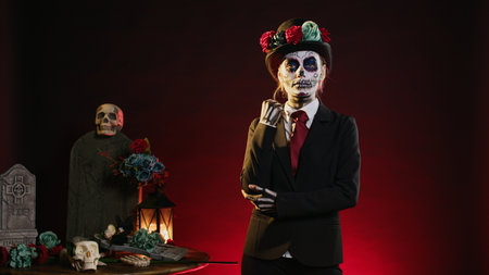 Creepy model in costume with skull make up celebrating mexican halloween, looking like lady of death. La cavalera catrina holy culture celebration with black and white body art.の写真素材
