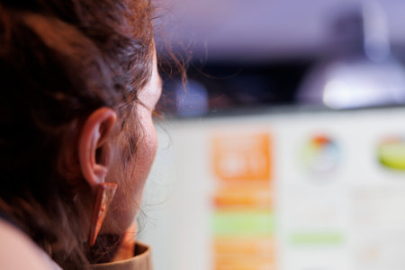 Entrepreneur analyzing financial graphs report on computer, working late at night at company...