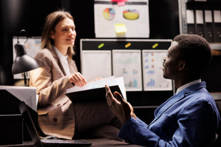Diverse depository workers analyzing bureaucracy record, working overhours at accountancy report in arhive room. Businesspeople checking administrative documents in corporate repositoryの写真素材