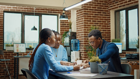 Furious man throwing files in boardroom, feeling stressed after team was failing to obtain new development plan. African america manager being angry and frustrated about office work results.の写真素材