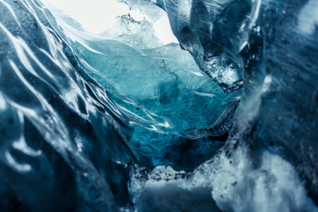 Frozen ice cap in vatnajokull caves melting due to global warming, frosty icelandic rocks forming massive crevasse and glacier hiking tunnels. Transparent glacial texture on cracked ice blocks.の写真素材