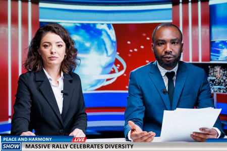 Newscasters present start of citizens rally, celebrating diversity in the city. Team of diverse broadcasters talking about pride parade modern event, creating tv reportage for peace and equality.の写真素材