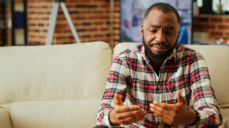 Remote professional holding q a session with webinar participants via video conference meeting in cozy apartment. Online video call host engaging in online discussions with traineesの写真素材