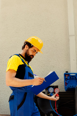 Competent mechanic filling out revision of insurance contract for home owner to sign after finishing...