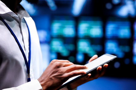 Specialist using mock up tablet to check server rigs doing intense computations. Technician preventing strain on data center infrastructure caused by AI applications driving up power usageの写真素材