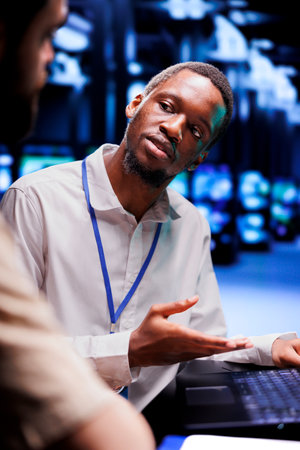African american expert and colleague dealing with server room system failures. Computer scientists...