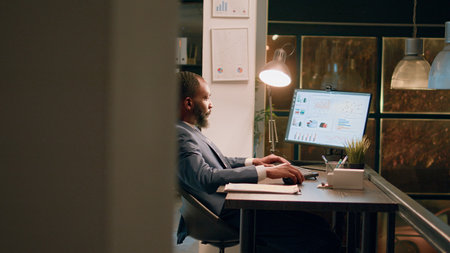 Business administrator showing assistant project results on laptop, crosschecking financial...
