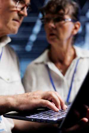 Octogenarian IT developers running analysis on server rows helping businesses manage databases, host...