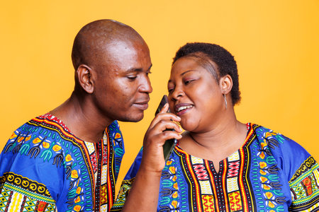 Man and woman couple using mobile phone as microphone. African american singers singing together in smartphone mic, recording song with telephone voice recorder applicationの写真素材