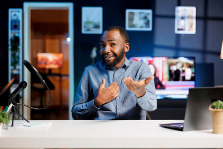 African american content creator doing travelling recommendations type of video for fans, filming in his apartment. Online show host sharing with viewers his favorite citiesの写真素材