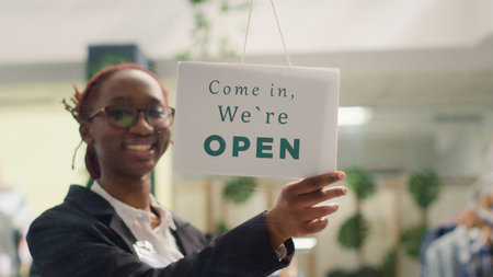 African american employee opening clothing store in the morning, waiting for customers. BIPOC retail...