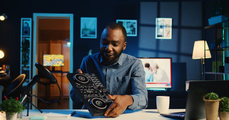 Artist filming DJ mixing tutorial showing examples of sampling on sound controller to audience. Viral internet star showing modern musical equipment to subscribers in home studioの写真素材