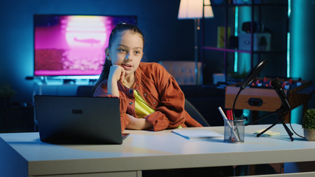 Young kid filming family vlog in home studio, talking about boring day at school for her children audience. Little girl recording content for online channel, discussing with gen Z viewersの写真素材