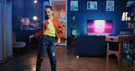 Energetic kid getting tons of engagement on her dancing clips posts recorded at home. Child filming viral videos in apartment, impressing children viewers with dance movesの写真素材