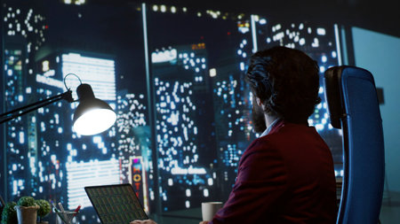 Investment banking analyst evaluating fiscal projections and managing funding deals to support expanding company on global scale. Skilled consultant seeks to boost earnings, admiring metropolis view.の写真素材