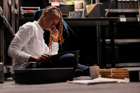 Tired sleepy african american woman investigator working overtime in police office. Overworked...