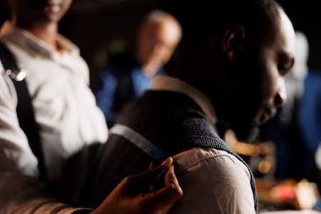 Close up of professional experienced tailor taking sartorial business suit vest measurements on...