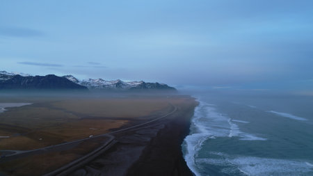 Iceland landscape black sand beach with atlantic ocean shore, majestic nordic country with natural scenery. Drone shot of icelandic nature with waves hitting the coastline, skyline. Slow motion.の写真素材
