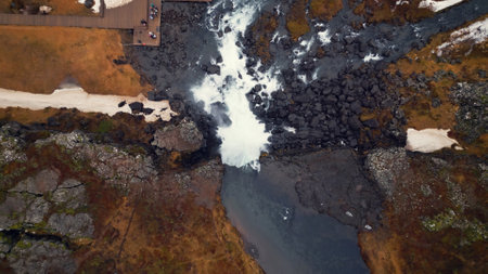 Aerial view of arctic oxarafoss cascade in iceland, spectacular nordic landscape with massive waterfall and cliffs. Majestic river flow running down off of frozen hills. Slow motion.の写真素材