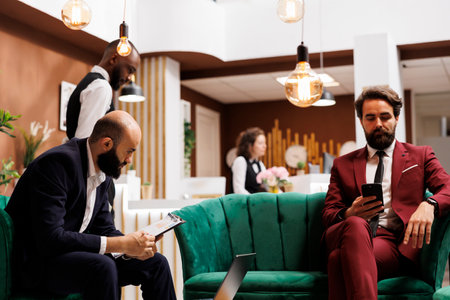 Business people travelling for work, using laptop and smartphone to prepare for international conference ahead. CEO reviews notes and ideas to ensure future collaborations.の写真素材