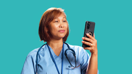 Close up shot of happy nurse in online videoconference meeting over the phone, greeting people....