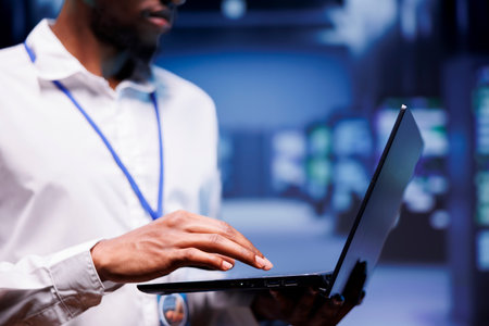African american admin in data center housing numerous servers, storage devices and networking...