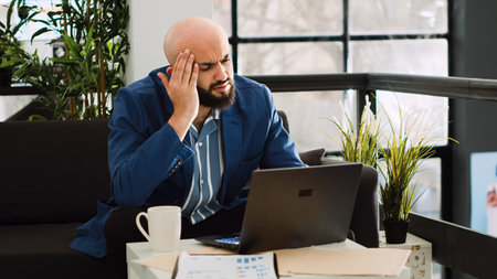 Analyst dealing with headache at work, trying on examine annual data strategy but feeling unwell....