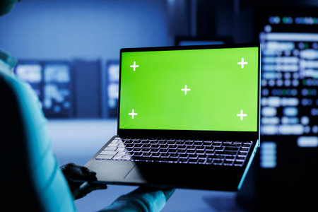 Computer scientist builds firewall protection systems in server room housing advanced infrastructure. High tech business manager runs code on mockup laptop to upgrade data center rigsの写真素材
