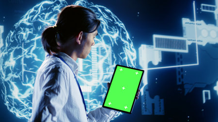 Licensed admin using mockup tablet to write artificial intelligence script code in startup workplace. Meticulous specialist doing maintenance work in data center, updating AI systemsの写真素材