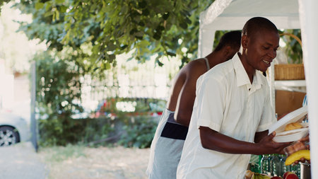 Multiracial organization working outside to feed the hungry and homeless, supplying them with essentials. The poor, needy and underprivileged receiving free food and provisions from volunteers.の写真素材