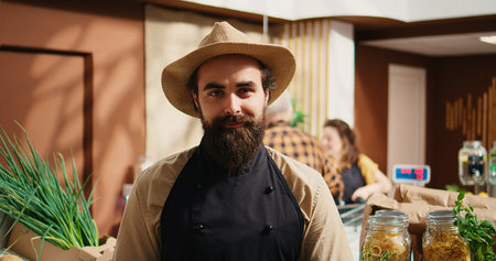 Portrait of smiling vendor adding pantry staples on sustainable zero waste supermarket shelves. Happy seller restocking local neighborhood grocery store with organic food in reusable jars, close upの写真素材