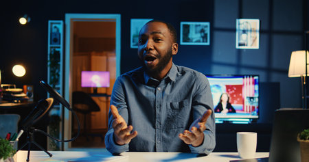 Happy influencer in home studio using professional camera and mic to film live broadcast for online...