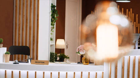 Trendy entryway with inviting interior design helps to make holiday resort customers feel relaxed. Front desk and lounge area are empty, featuring expensive decor inside spectacular hotel lobby.の写真素材