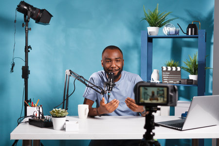 African american blogger creating professional video content with camera while streaming in studio....