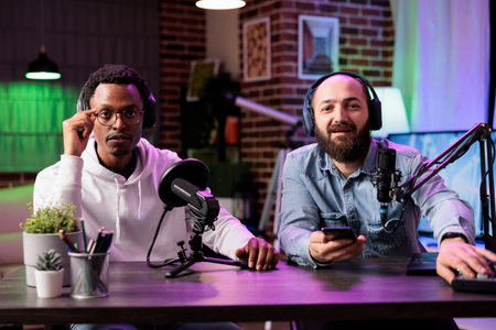 Skillful cohosts presenting entertaining show in professional studio produced for streaming services. Presenter using high quality recording setup to film internet channel vlogの写真素材