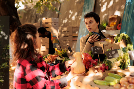 Young woman small business owner selling fresh and healthy organic products. Female customer buying...