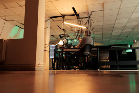 Diverse team of spies coding online virus program, stealing private information and passwords. Cybercriminals working together on identity theft and asking for ransomware at night.の写真素材